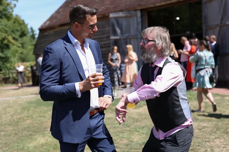 Candid wedding guests outside chat Essex