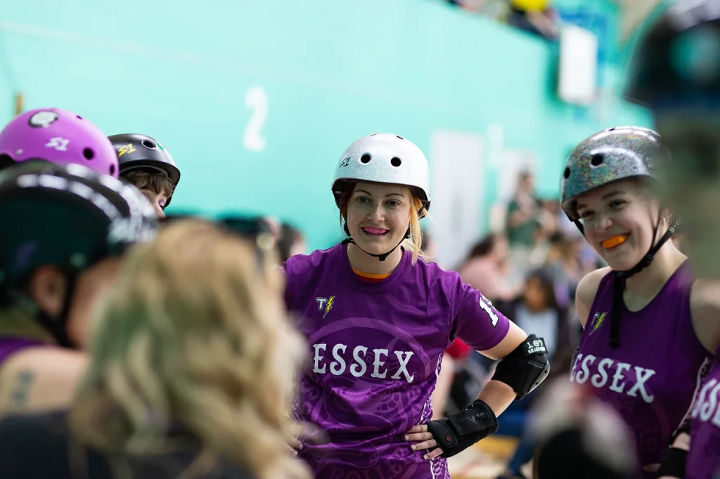 A group wearing helmets and purple team shirts