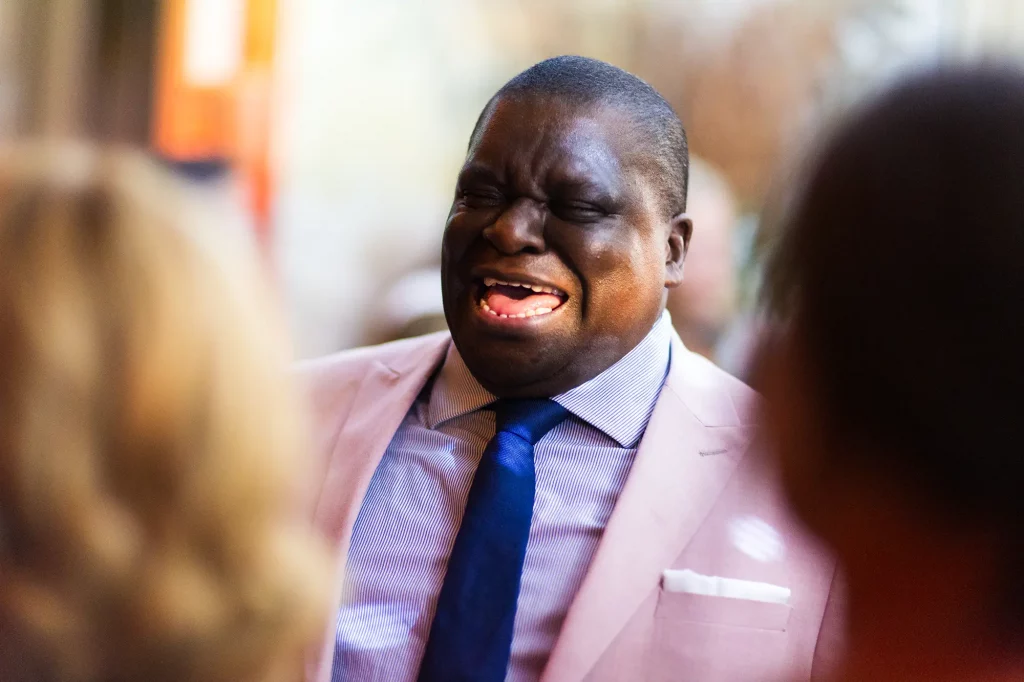 Relaxed wedding guest laughing