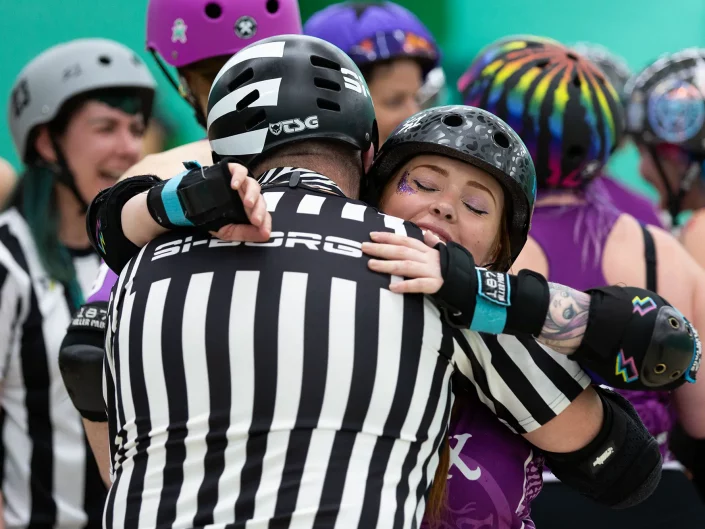 Essex Roller Derby team member hugging referee